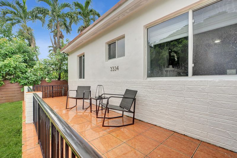 Tiled front terrace with seating along the facade