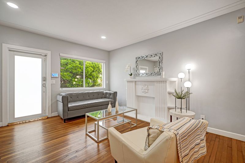 Living room with a mantel, a glass door and a garden window