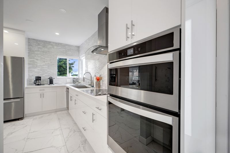 Kitchen with white cabinetry, a stainless wall oven and tile floors