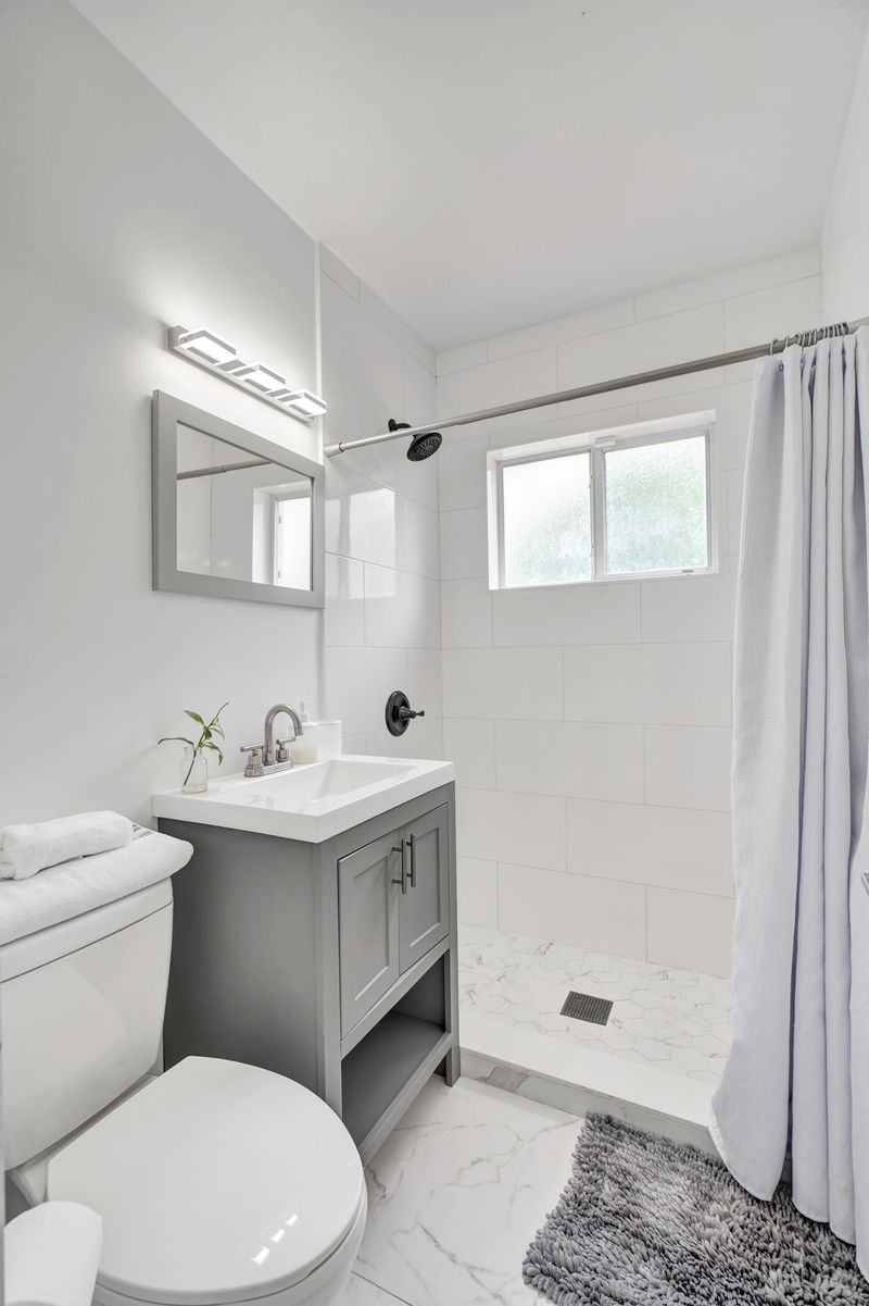 Second bathroom with a gray vanity and walk-in shower