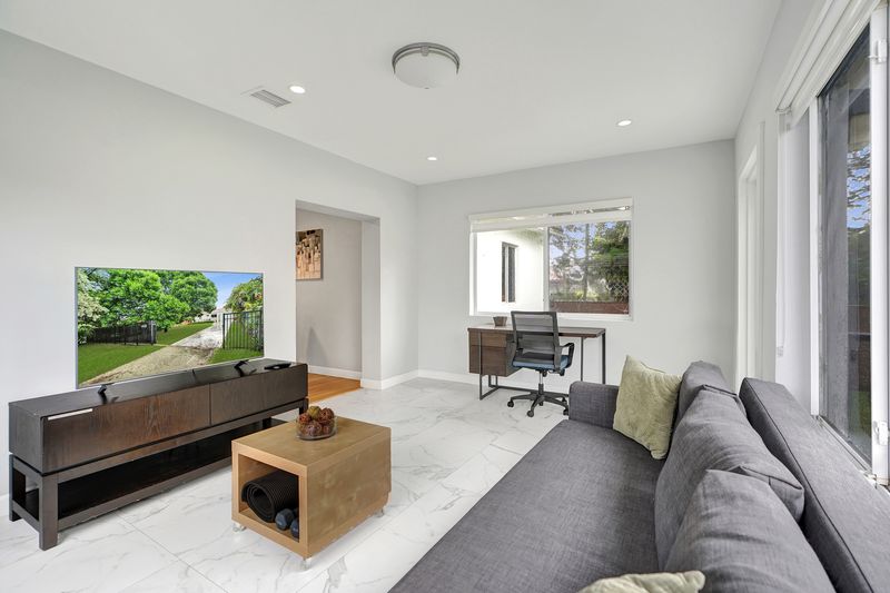 Florida room with tile floors and a desk area