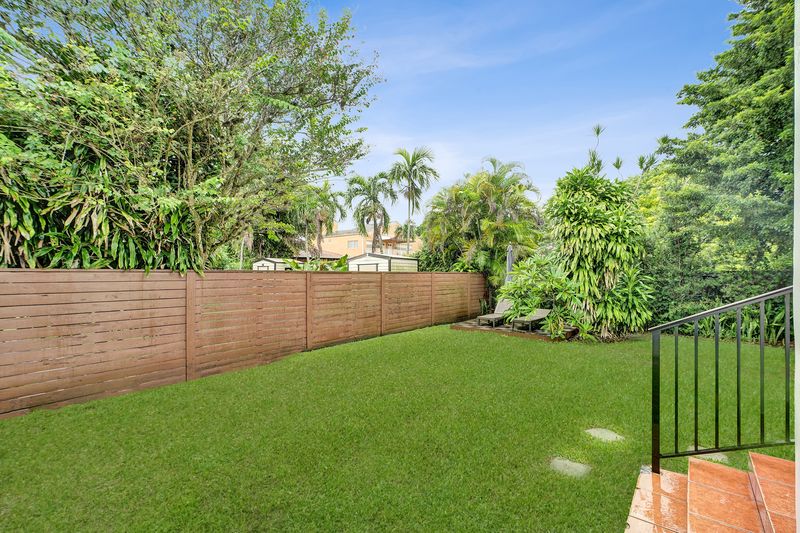 Fenced backyard with lawn and a wood privacy fence