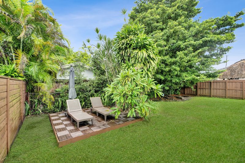 Backyard deck with lounge chairs among tropical plants
