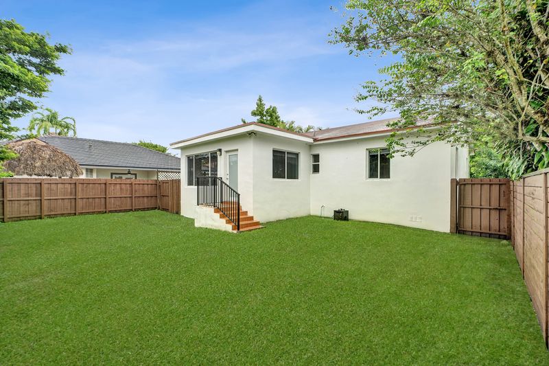 Rear of the home across the fenced backyard