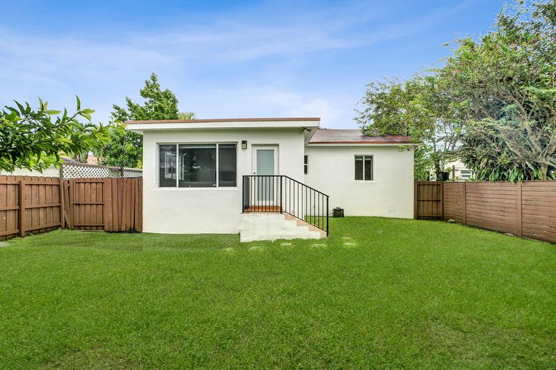 Rear of the home with steps down to the lawn