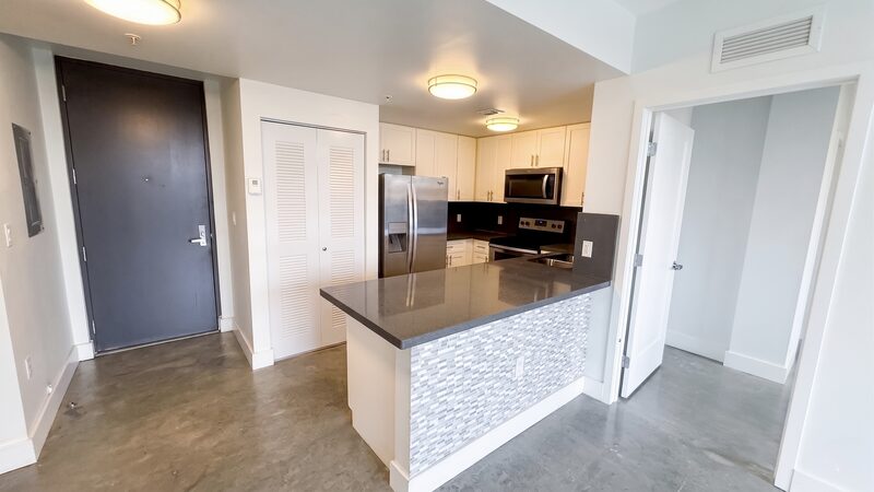 Apartment kitchen with dark stone counters and polished concrete floors at 4332 W Flagler Street