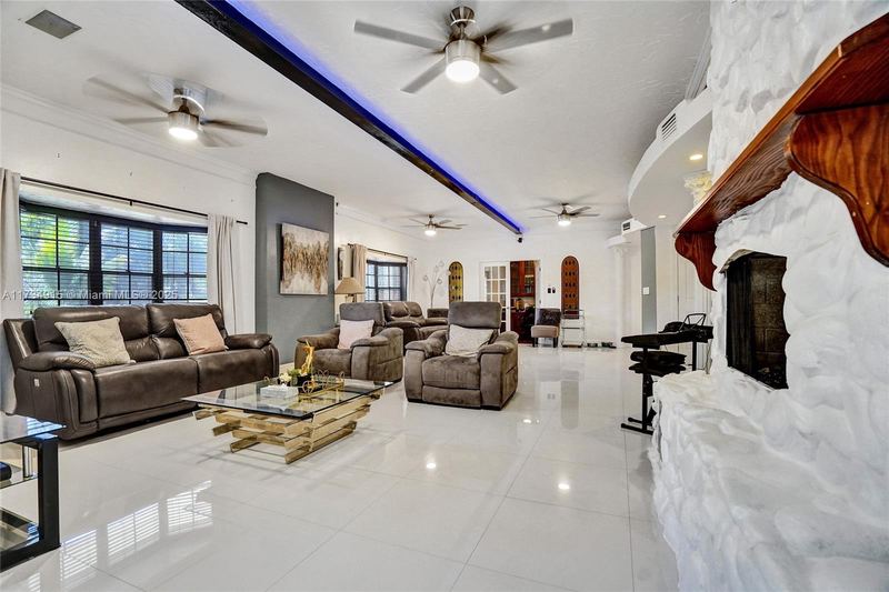 Living room with a white stone fireplace and leather seating