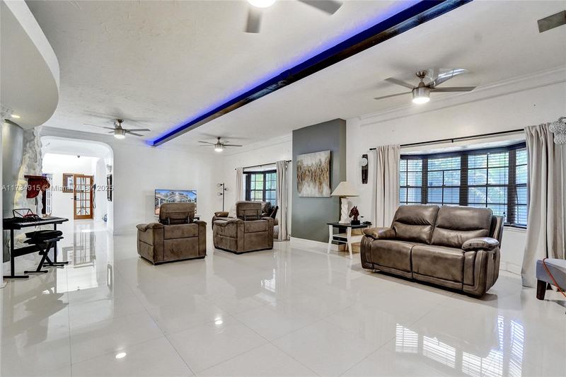 Long living room with tile floors and large windows