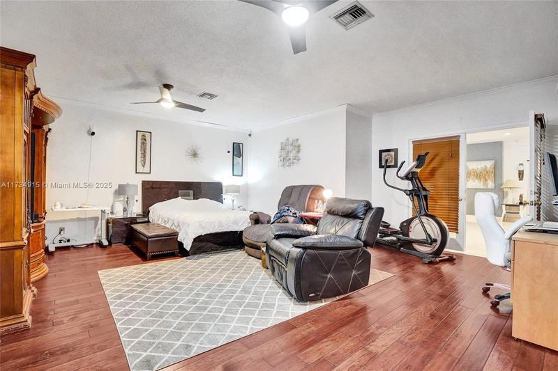 Bedroom suite with wood floors and an exercise area