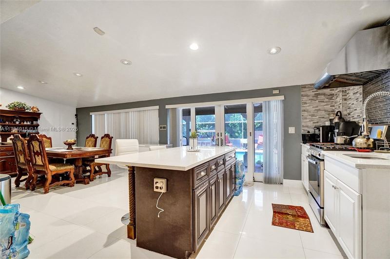 Kitchen island and dining area with French doors to the pool
