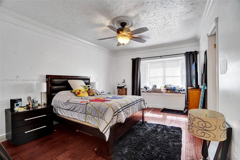 Bedroom with wood floors and a ceiling fan
