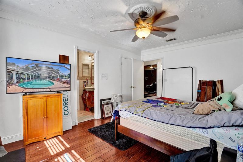 Bedroom with wood floors and a door to a bathroom
