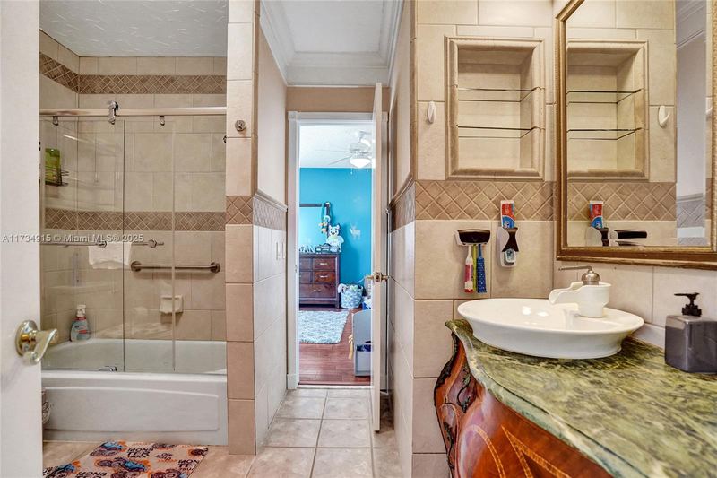 Bathroom with a tub-shower and a carved vanity
