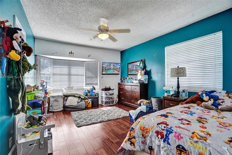 Bedroom with an accent wall and wood floors