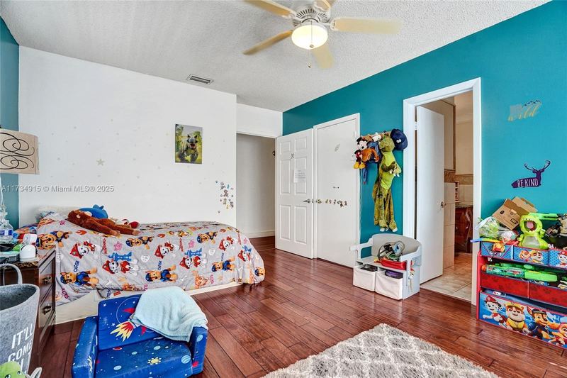 Bedroom with wood floors and a closet