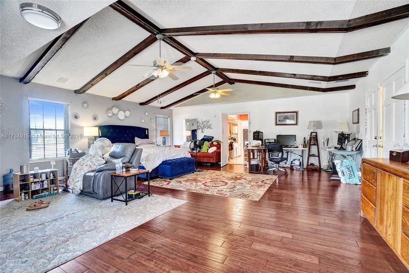 Primary suite with a beamed vaulted ceiling and sitting area