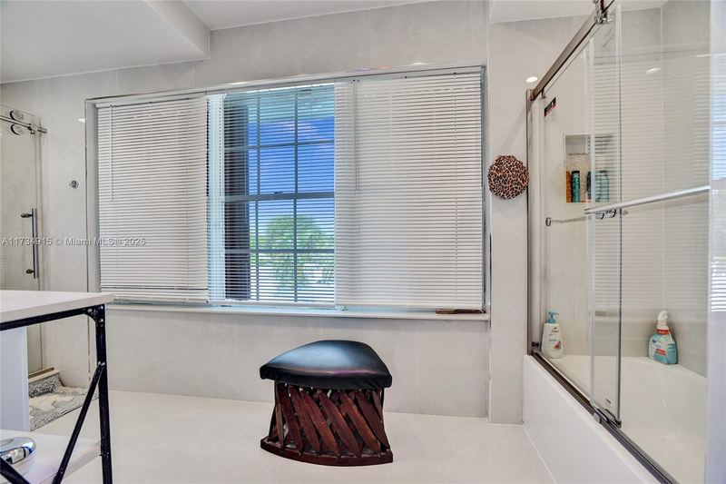 Bathroom with a tub and glass shower door