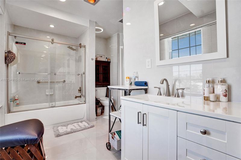 Bathroom with a tub-shower and white vanity