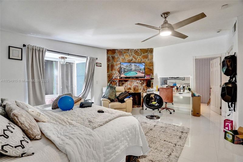 Bedroom with a stone fireplace and window seat