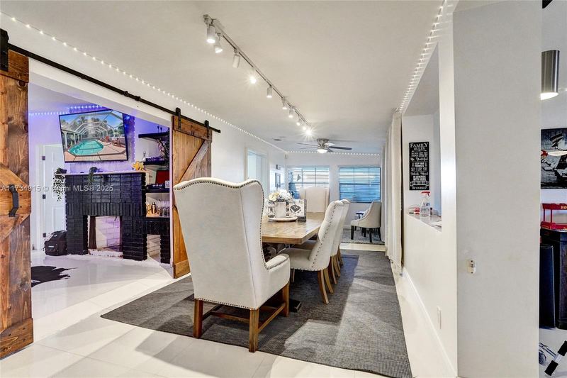 Dining area with a barn door and fireplace