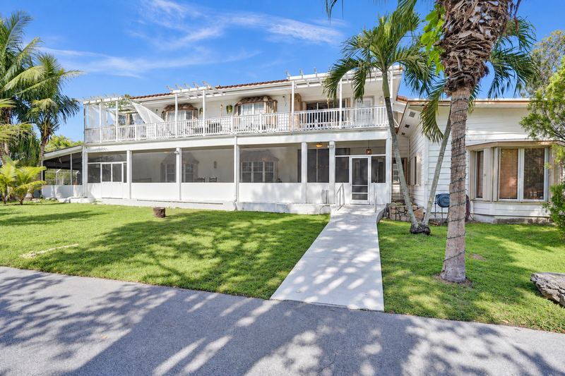 Rear of the house with a walkway and palms