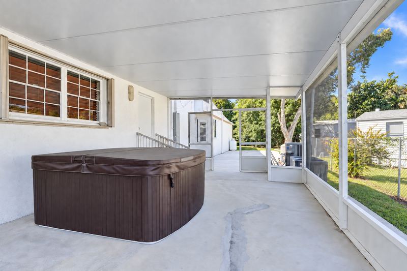 Covered patio with a hot tub