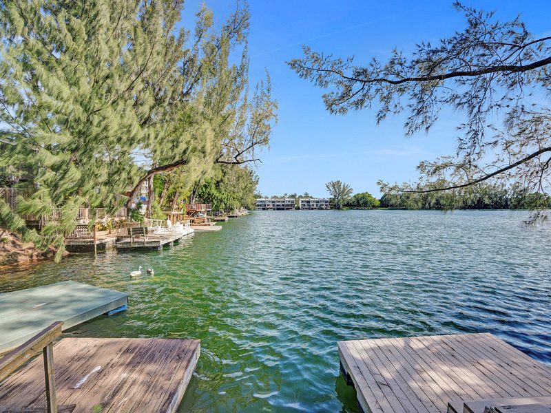 Private dock and open-water view of the 22-acre lake behind 4863 SW 71st Place in Glenvar Heights, Miami