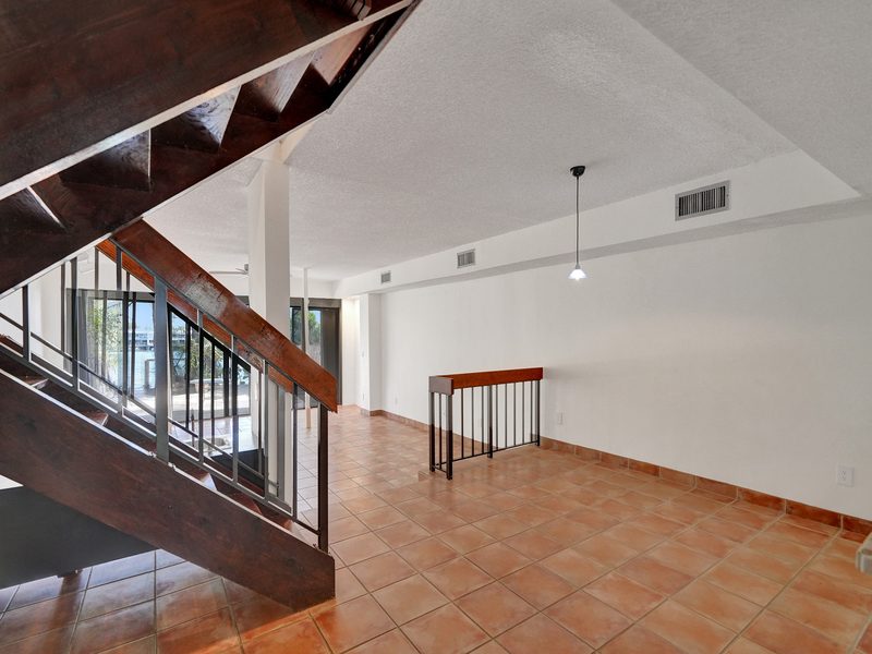 Living room with a vaulted wood-beam ceiling and staircase at 4863 SW 71st Place, Miami