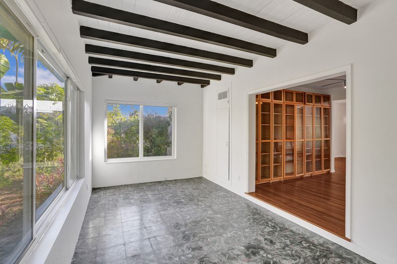 Back room with a beamed ceiling and windows to the yard