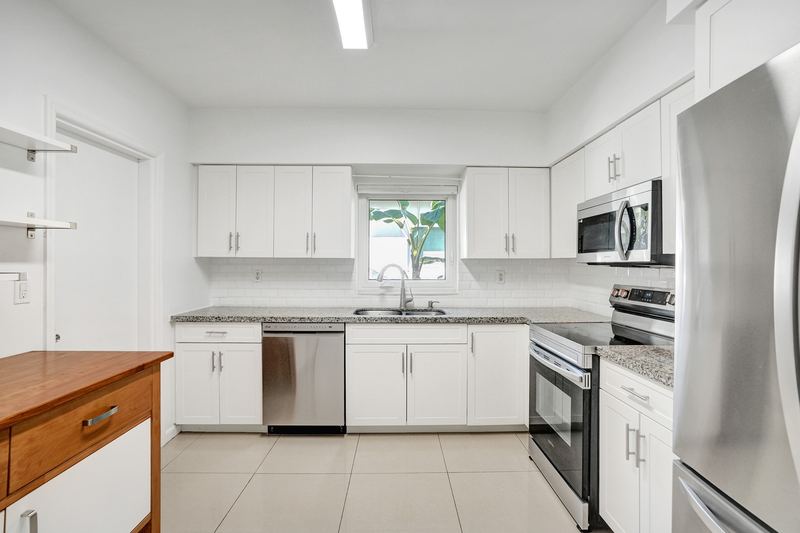 Kitchen with white cabinets, granite counters and stainless appliances