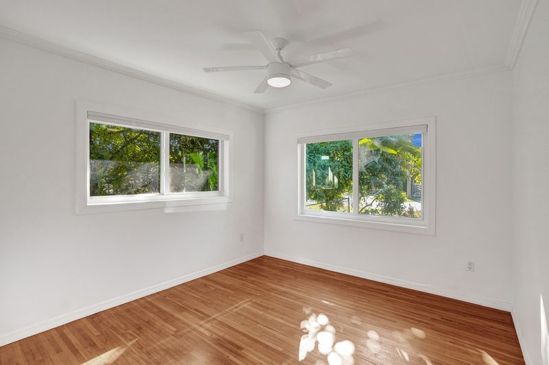 Bedroom with wood floors and two windows