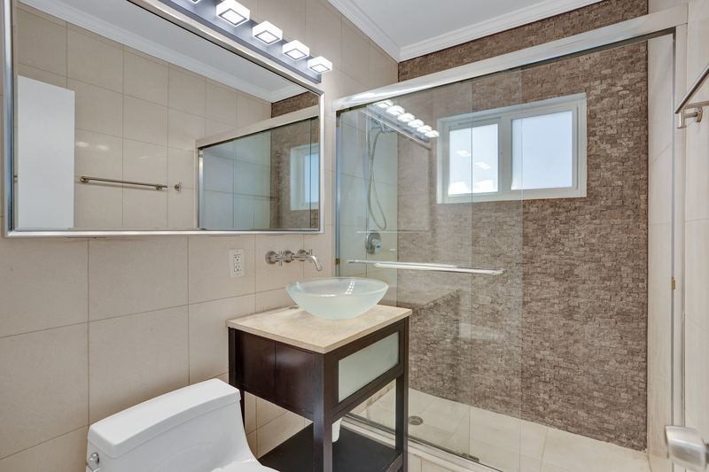 Bathroom with a vessel sink and glass-enclosed shower