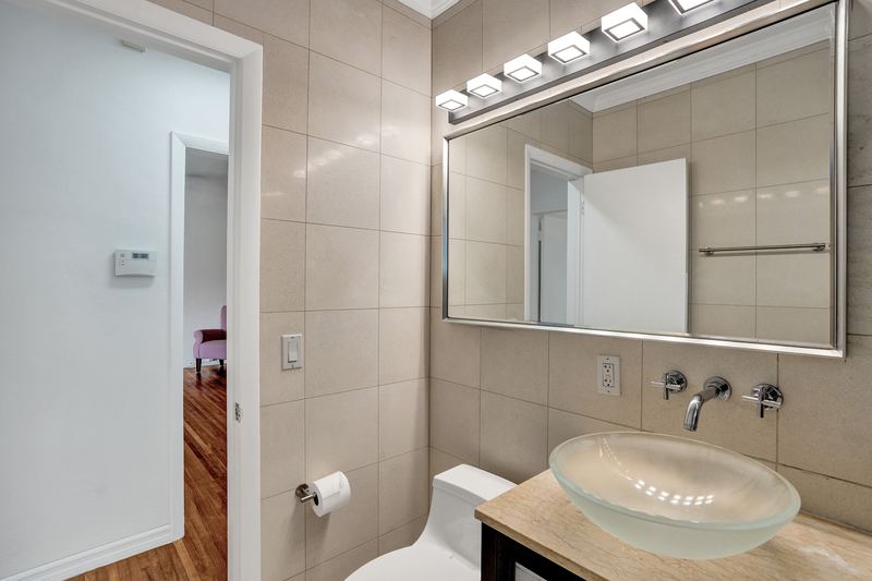 Bathroom vanity with a vessel sink and wall-mounted faucet