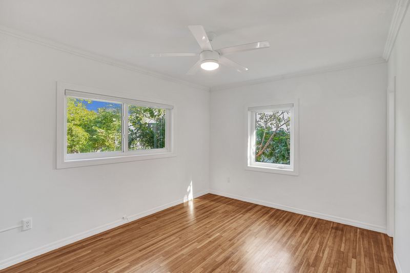 Bedroom with wood floors and windows to the garden