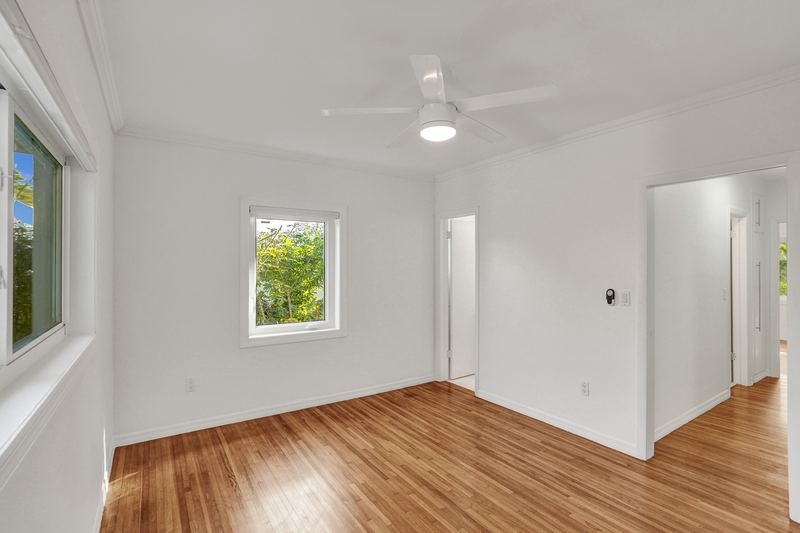 Bedroom with wood floors and a doorway to the hall