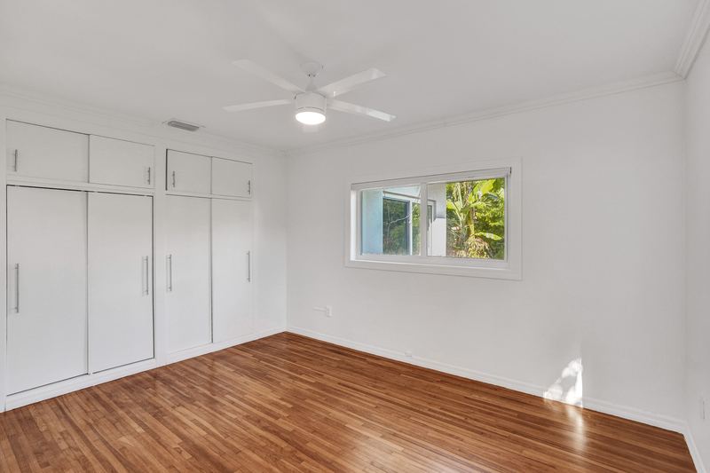 Bedroom with built-in closets and a ceiling fan