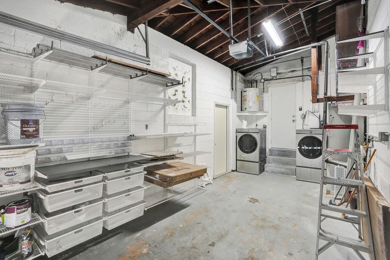 Garage with storage shelving and a washer and dryer