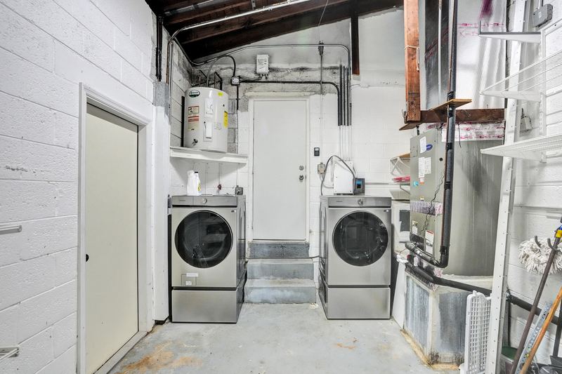 Garage laundry area with washer, dryer and water heater