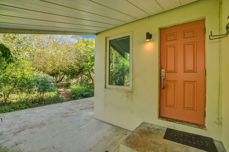 Covered back patio with a door to the house