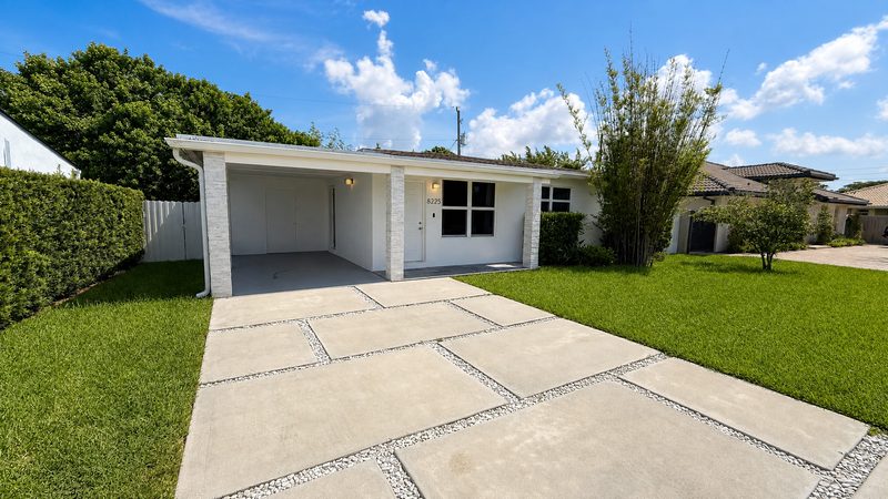 Front of the home with covered carport and paver driveway at 8225 SW 44th Street, Miami