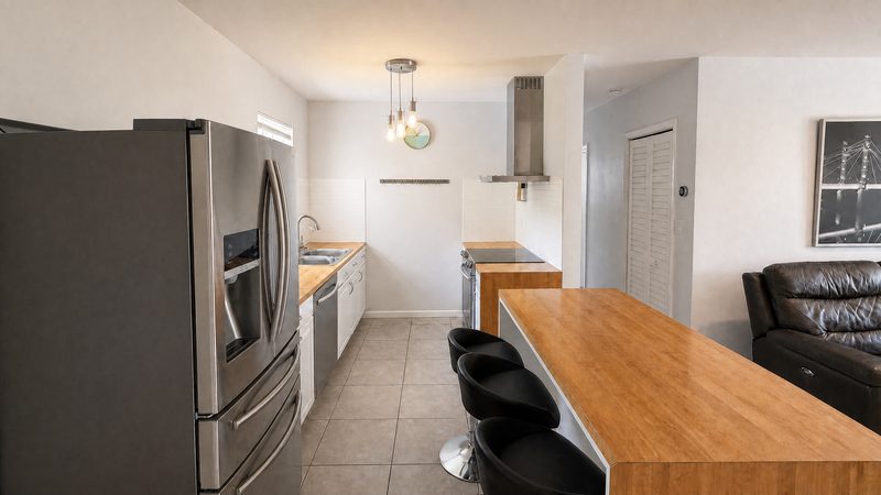 Kitchen with stainless refrigerator and breakfast bar at 8225 SW 44th Street, Miami