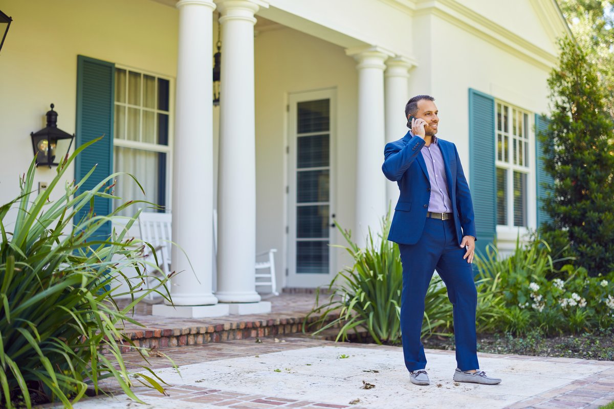 Jorge Guanche on the phone outside a luxury Miami home