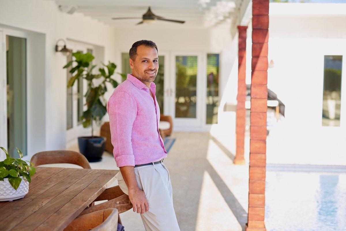 Jorge Guanche on a covered patio overlooking a pool at a modern Miami home